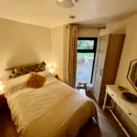 a bedroom with a bed and a mirror at Havendale Accessible Holiday Cottage