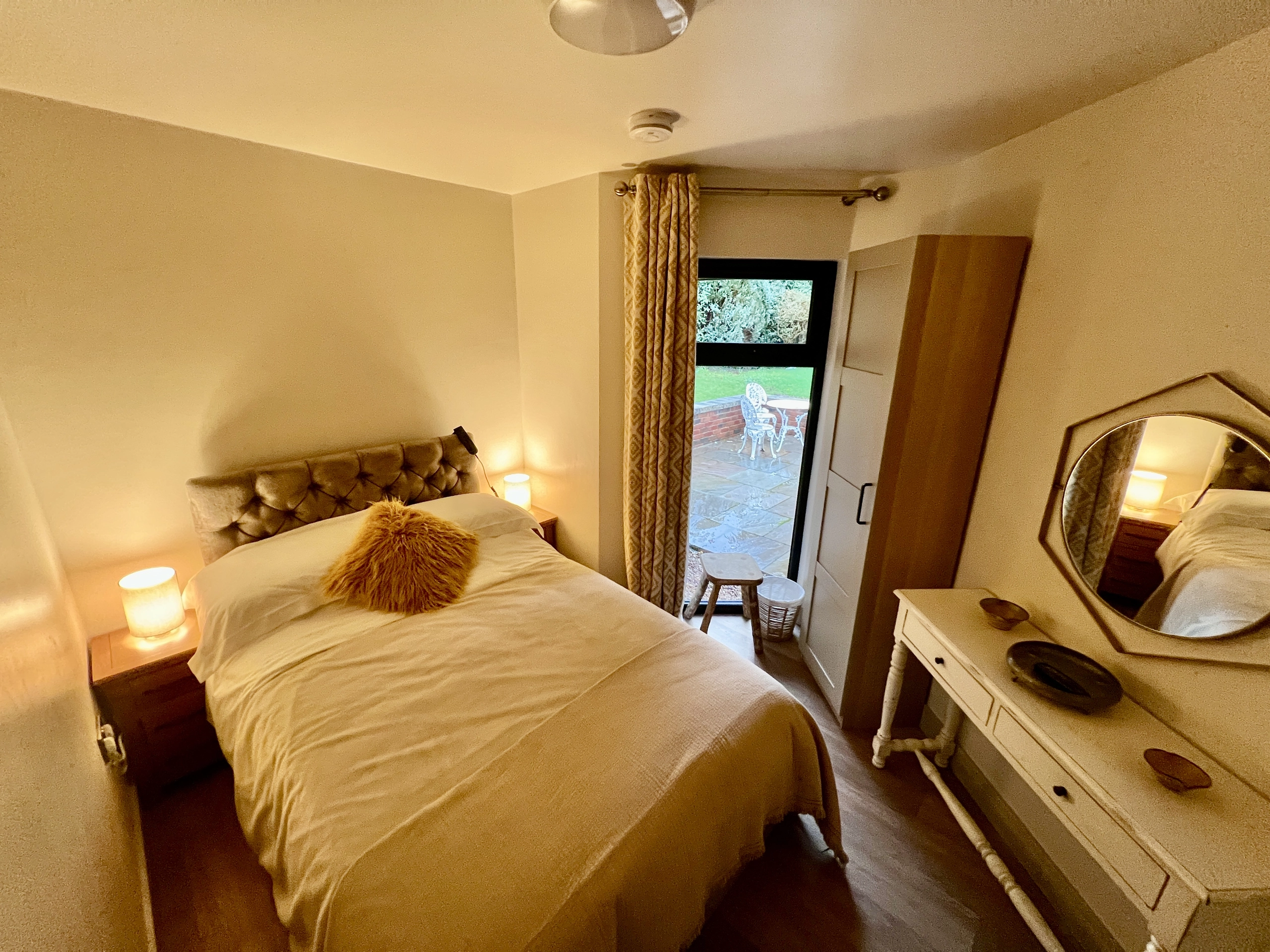 a bedroom with a bed and a mirror at Havendale Accessible Holiday Cottage