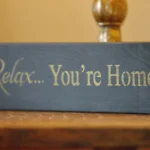 a wooden block with a sign that says relax you're home at Havendale Accessible Holiday Cottage