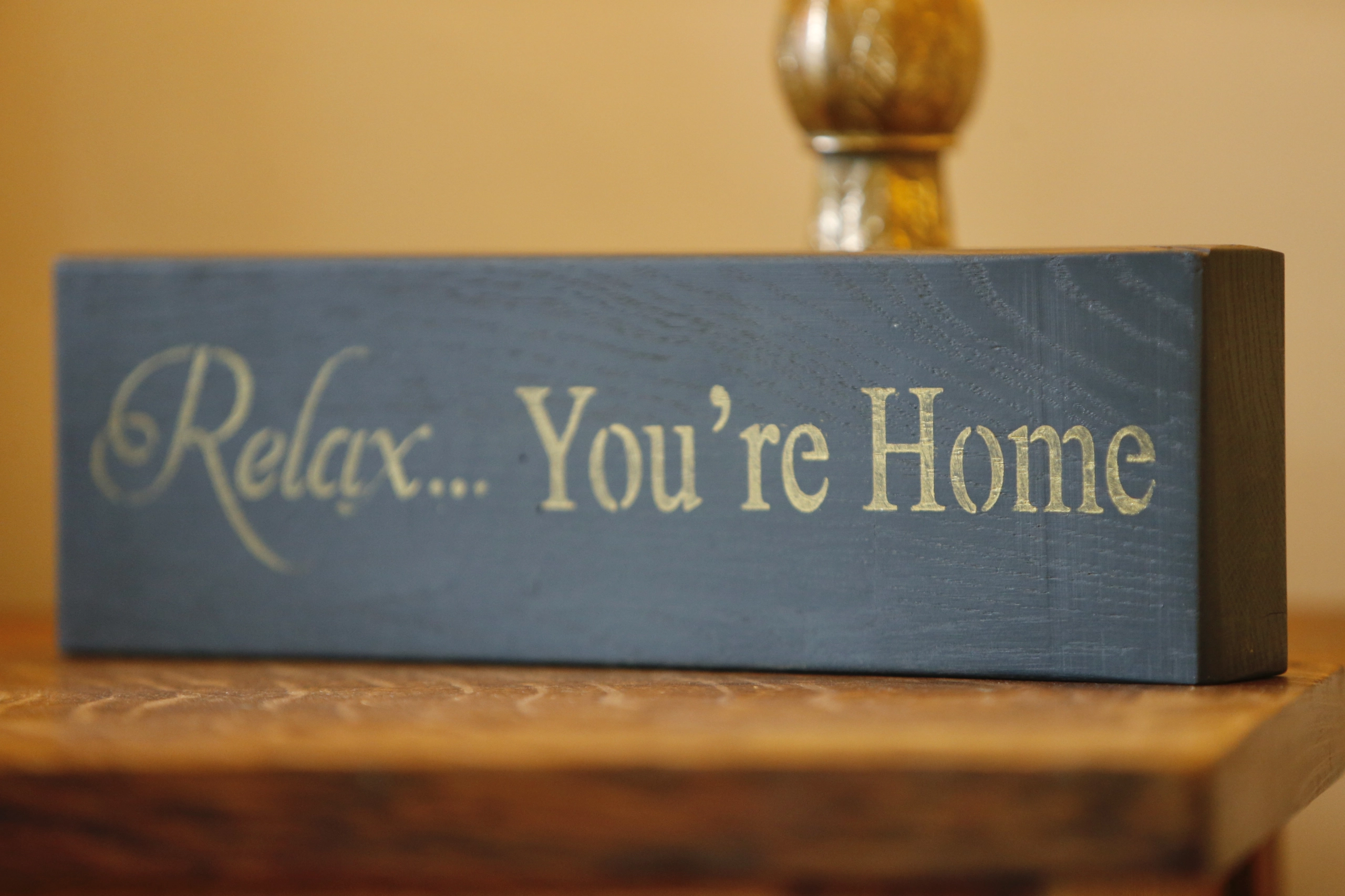 a wooden block with a sign that says relax you're home at Havendale Accessible Holiday Cottage