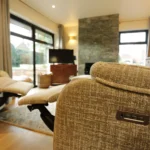 a living room with a couch and a television at Havendale Accessible Holiday Cottage