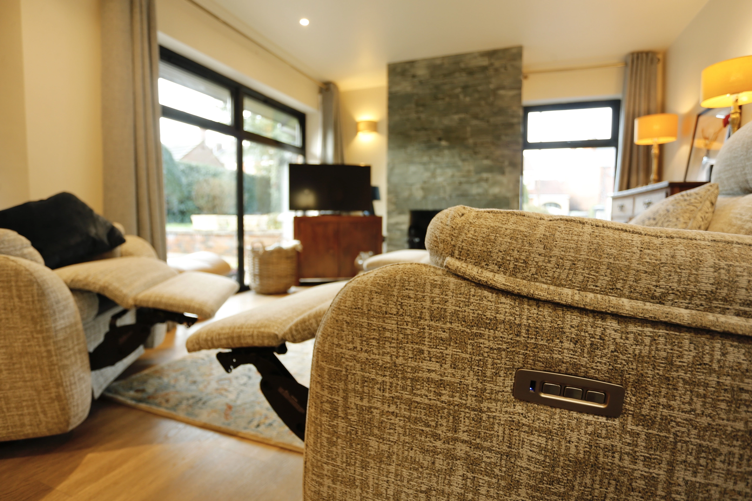 a living room with a couch and a television at Havendale Accessible Holiday Cottage
