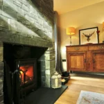 a fireplace with a fire in it at Havendale Accessible Holiday Cottage