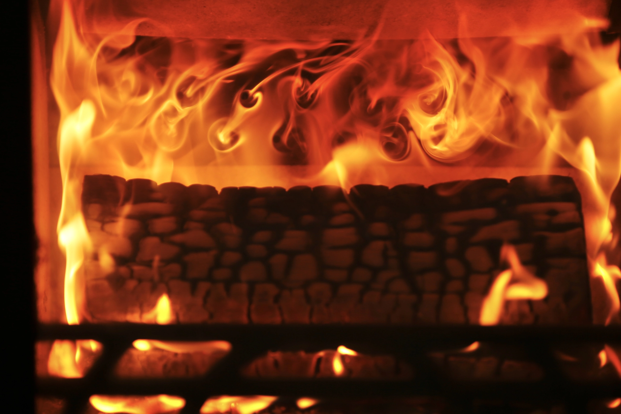 a fire burning in a fireplace with rocks and flames at Havendale Accessible Holiday Cottage