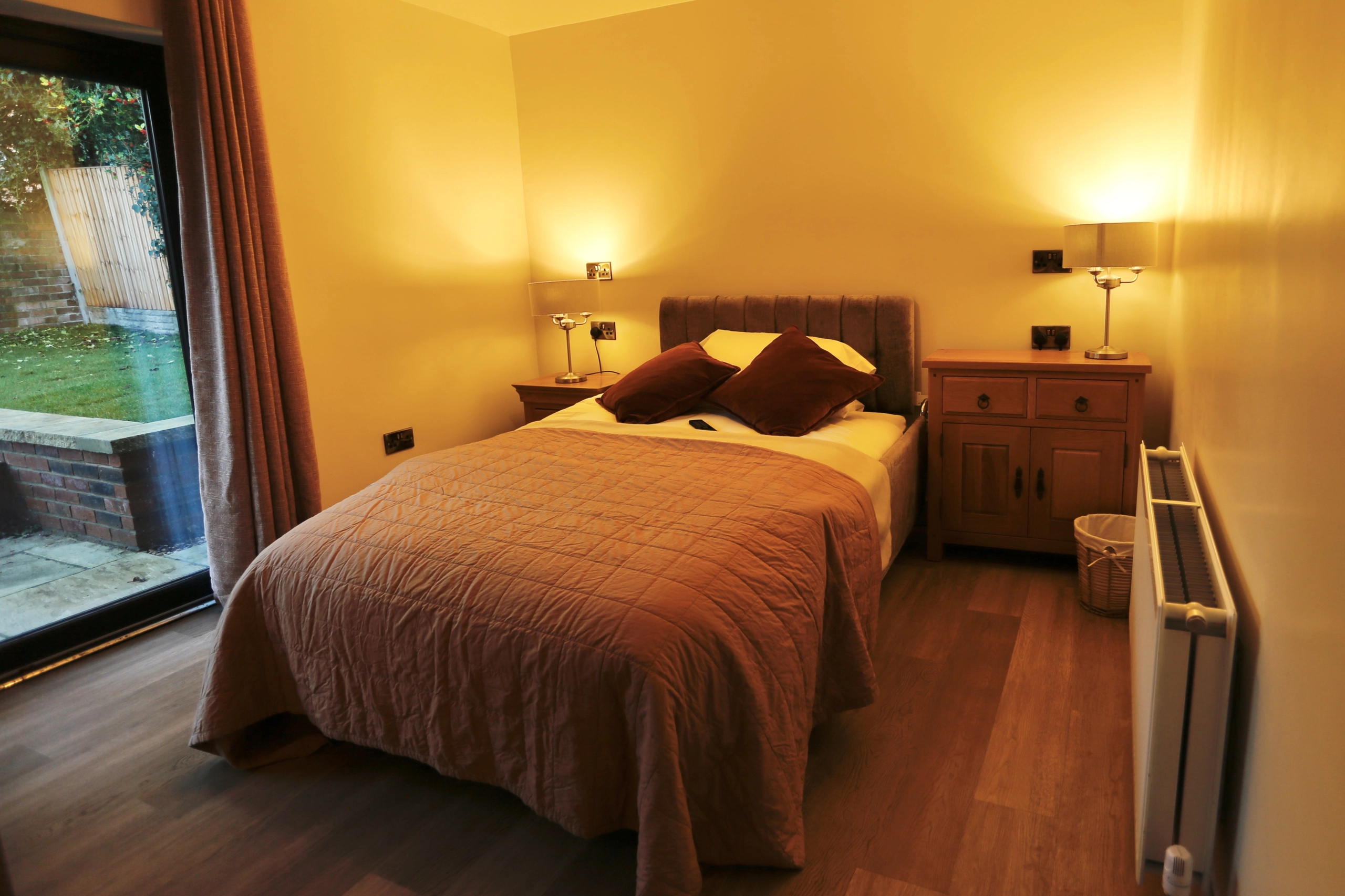 a bed with a brown comforter and a brown pillow at Havendale Accessible Holiday Cottage