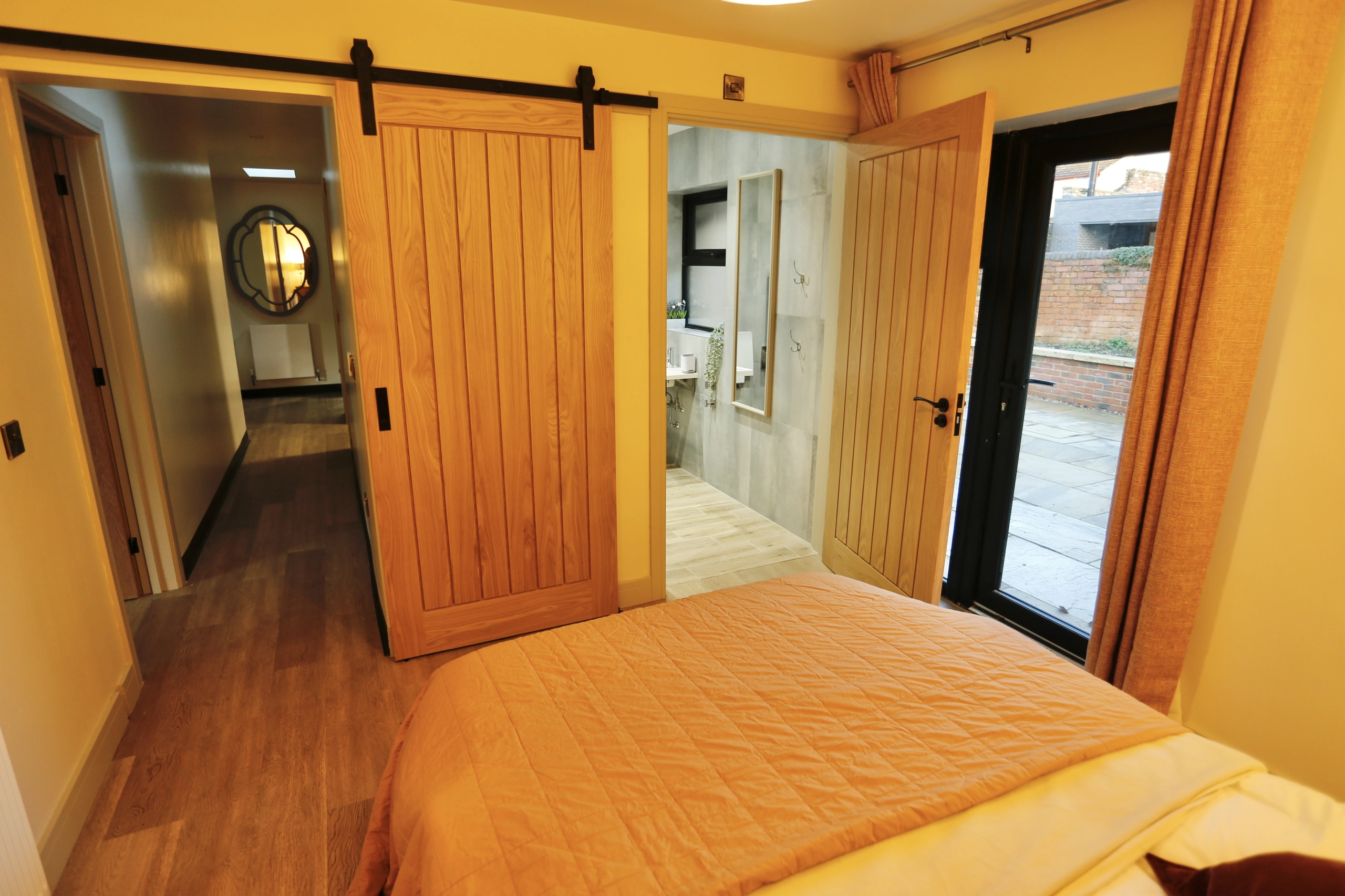 a bedroom with a bed and a mirror at Havendale Accessible Holiday Cottage