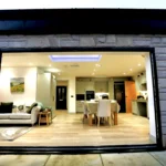 a living room with a large open door at Havendale Accessible Holiday Cottage