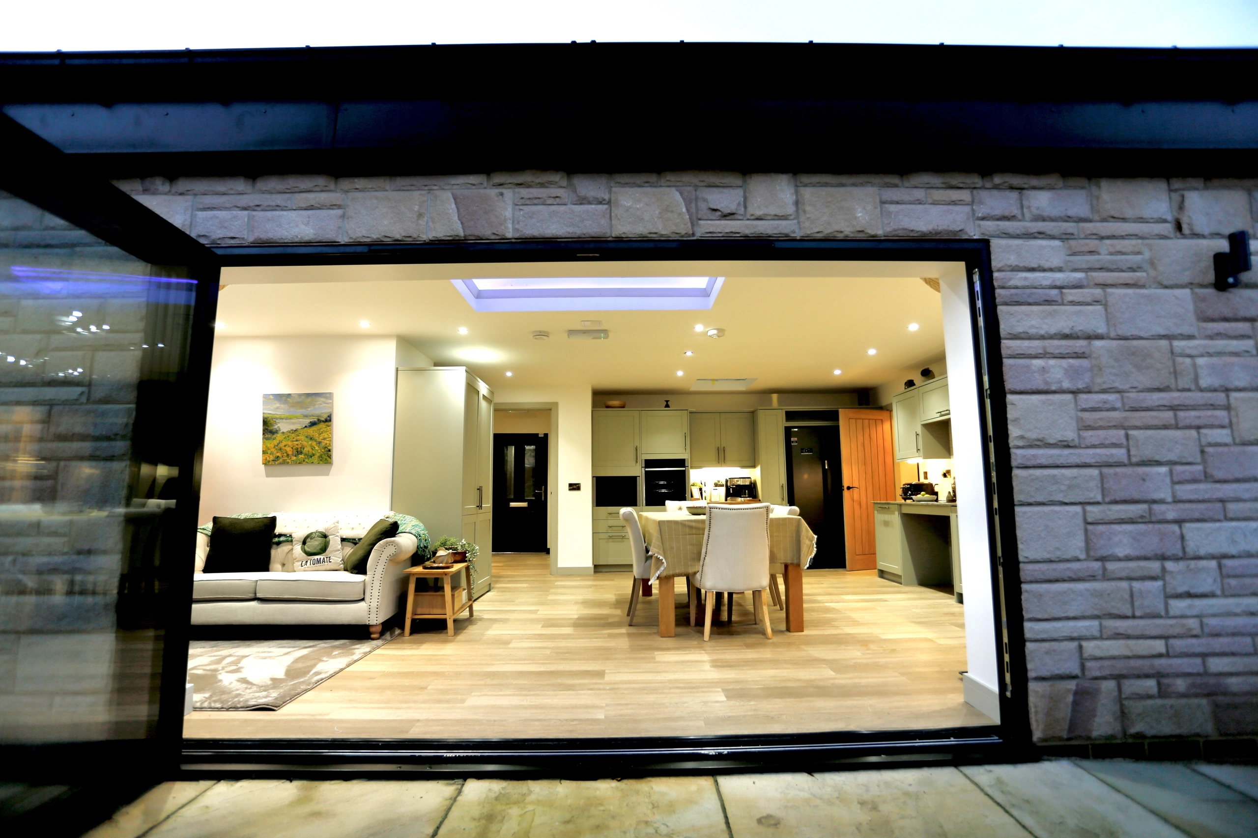 a living room with a large open door at Havendale Accessible Holiday Cottage