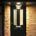 a cat is sitting in front of a door at Havendale Accessible Holiday Cottage