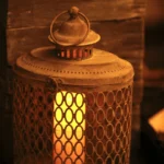 a candle is lit in a small metal lantern at Havendale Accessible Holiday Cottage