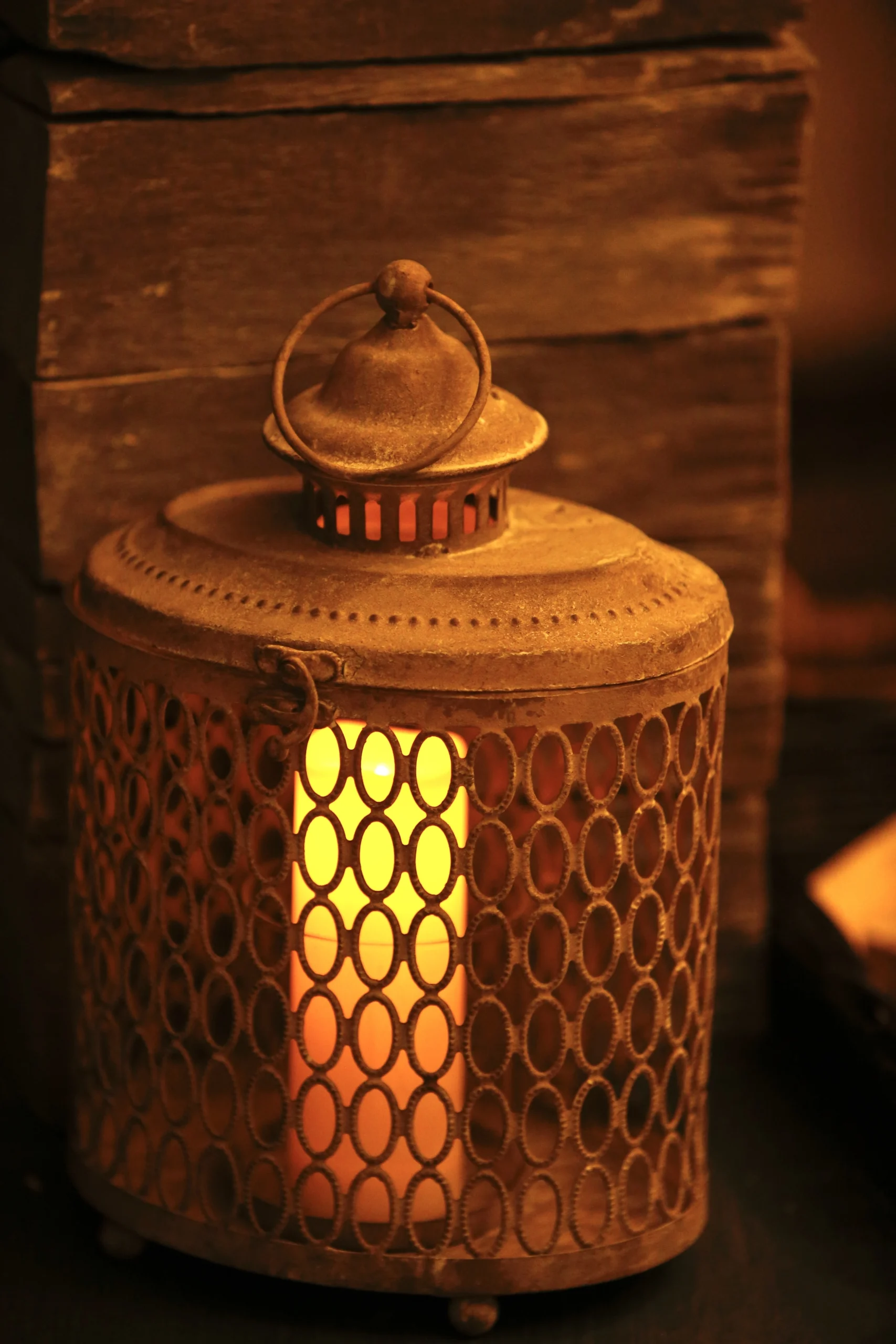a candle is lit in a small metal lantern at Havendale Accessible Holiday Cottage