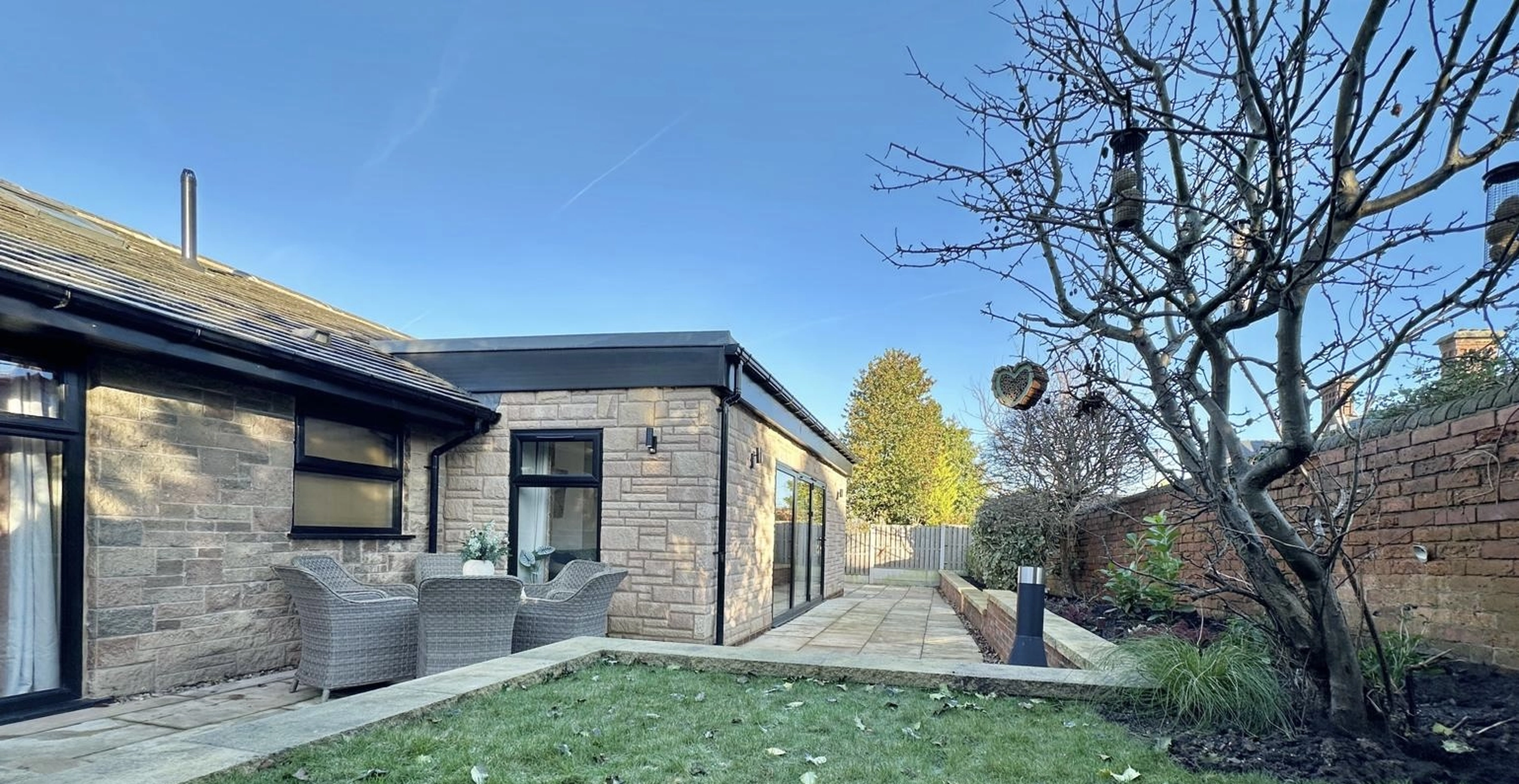 a house with a tree in the yard at Havendale Accessible Holiday Cottage