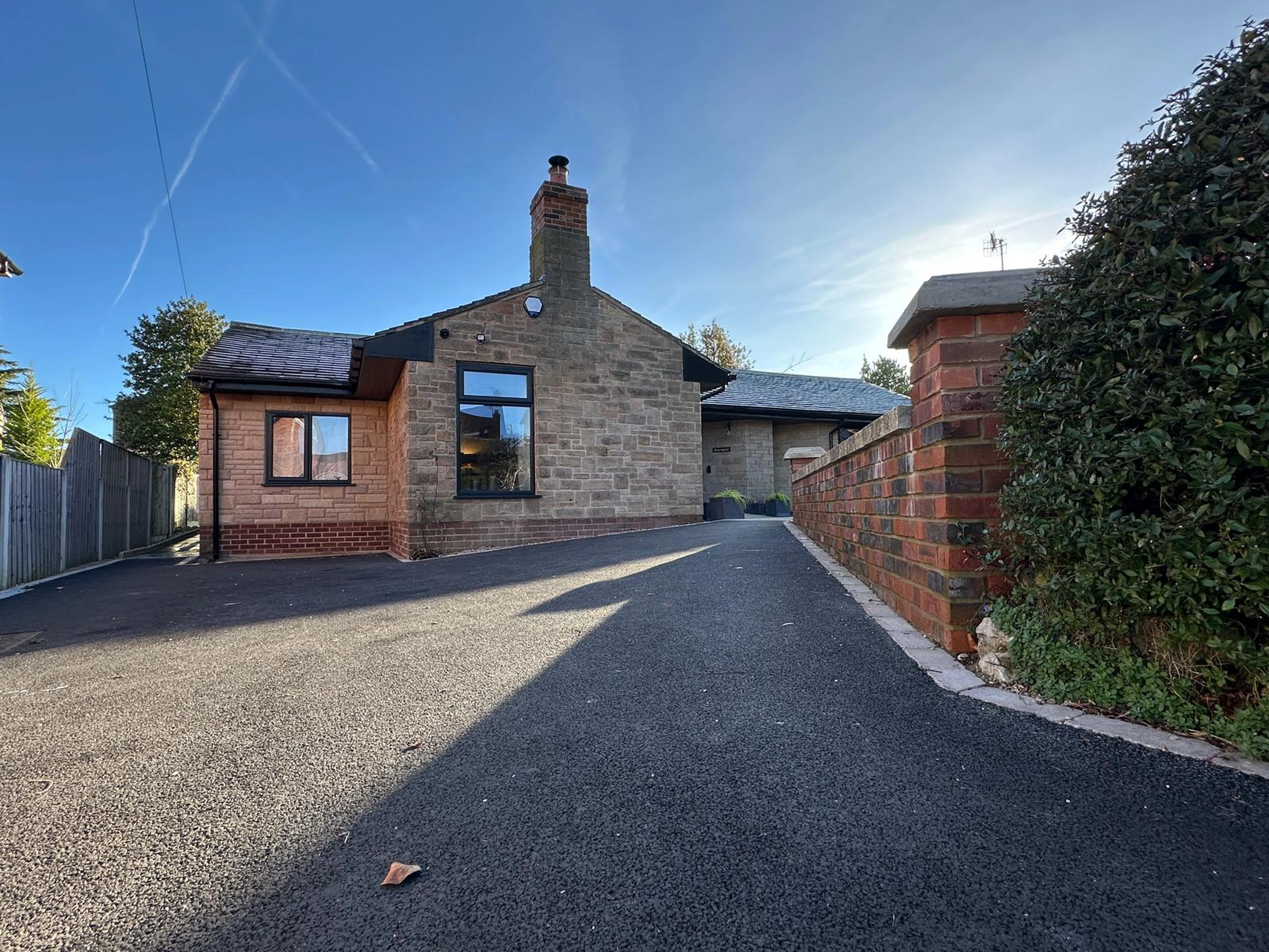 a brick house with a driveway and a gate at Havendale Accessible Holiday Cottage