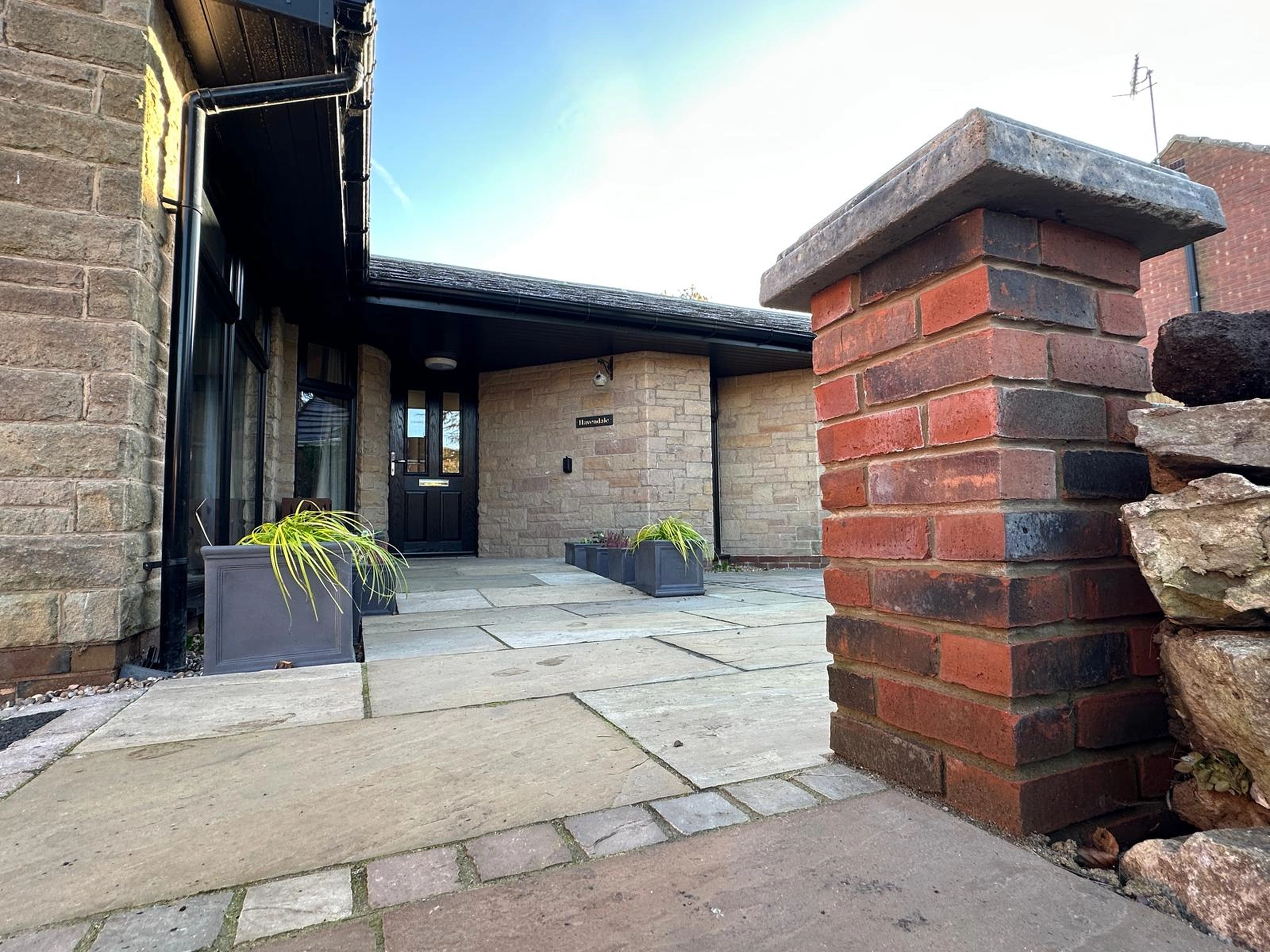 a brick building with a door and a brick wall at Havendale Accessible Holiday Cottage