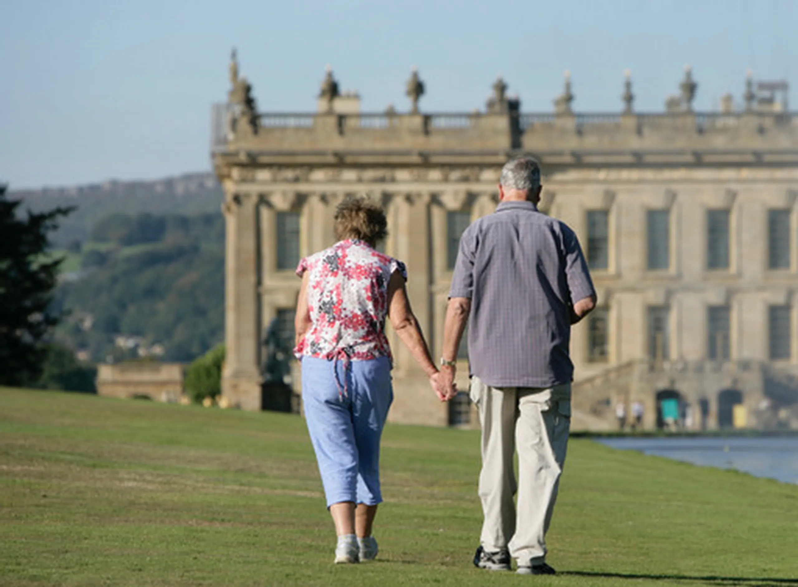 a man and woman walking on a grassy field at a landmark near Havendale Accessible Holiday Cottage