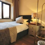 a bed with a white comforter at Havendale Accessible Holiday Cottage