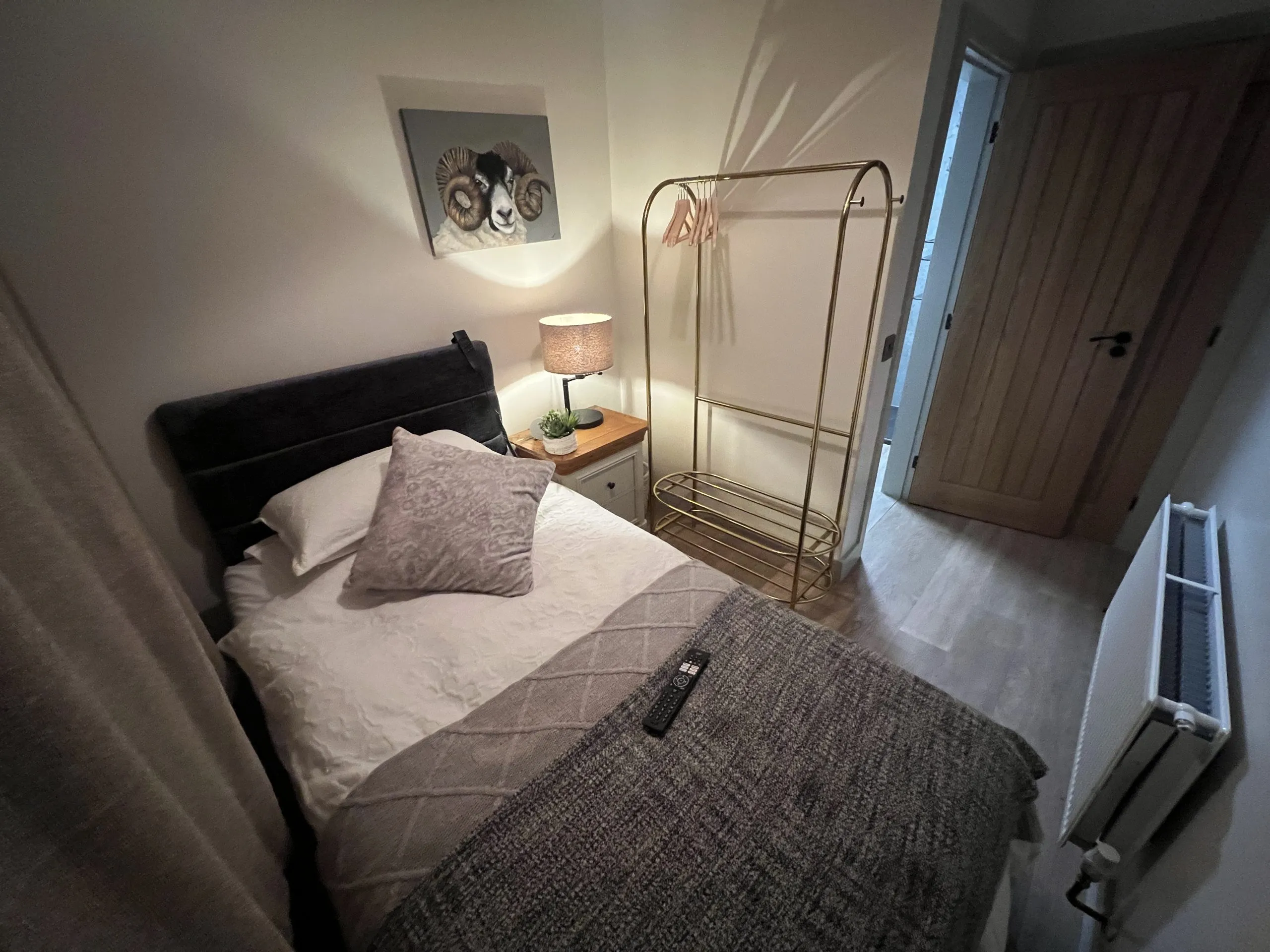 a bed with a blanket and a lamp at Havendale Accessible Holiday Cottage