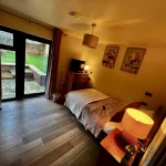 a bedroom with a bed and a door at Havendale Accessible Holiday Cottage