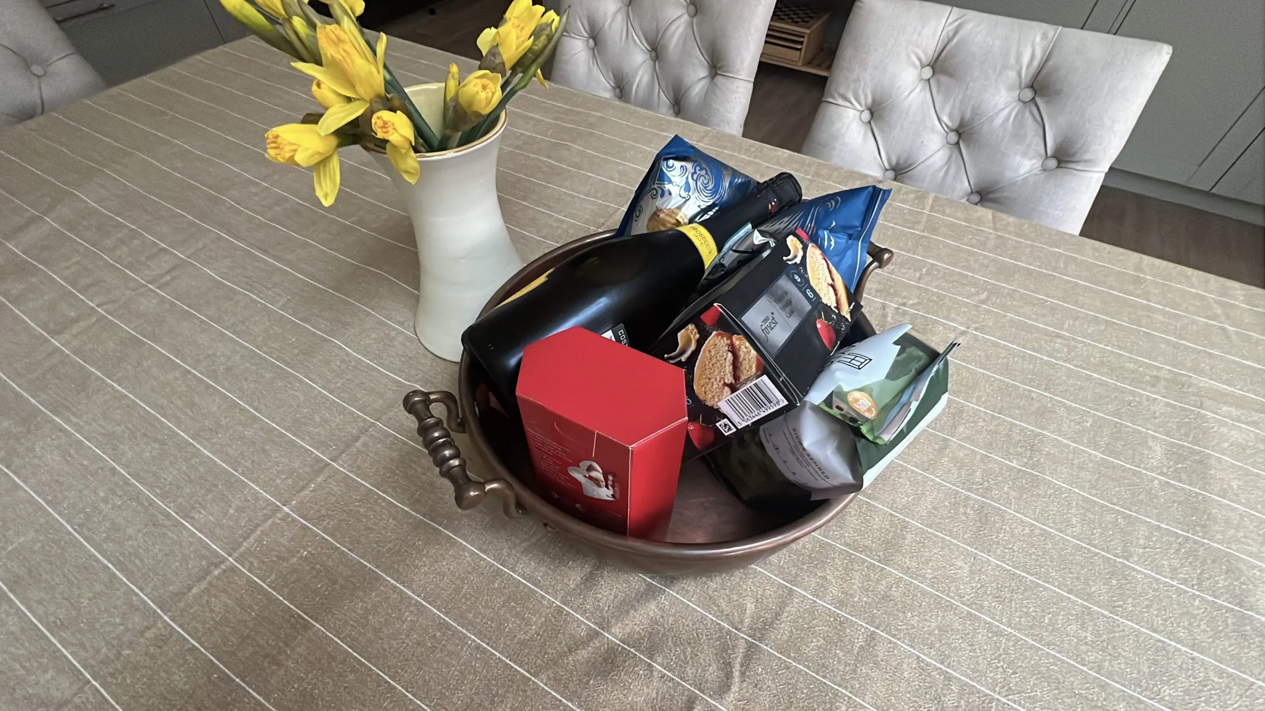 a bowl of food on a table with a vase of flowers at Havendale Accessible Holiday Cottage