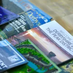 a pile of travel books and guides sitting on top of a table at Havendale Accessible Holiday Cottage