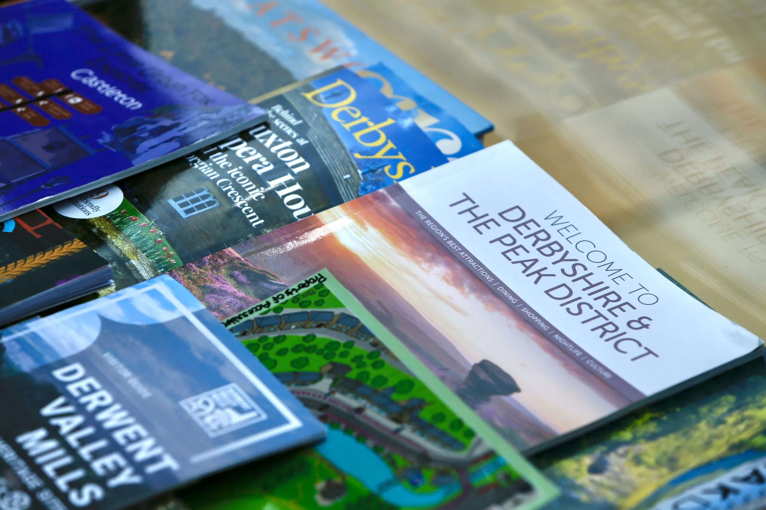 a pile of travel books and guides sitting on top of a table at Havendale Accessible Holiday Cottage