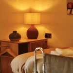 a bed with a lamp on top of it at Havendale Accessible Holiday Cottage