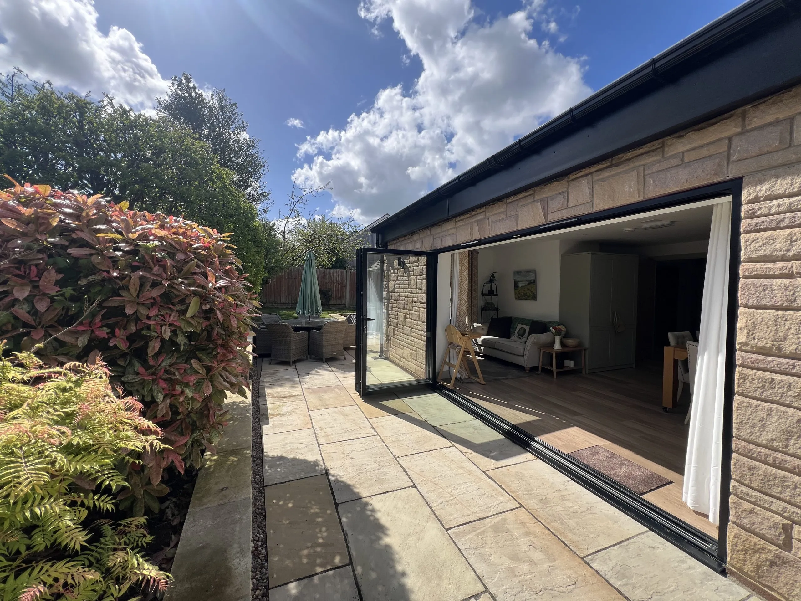 a house with a sliding door and a patio area at Havendale Accessible Holiday Cottage