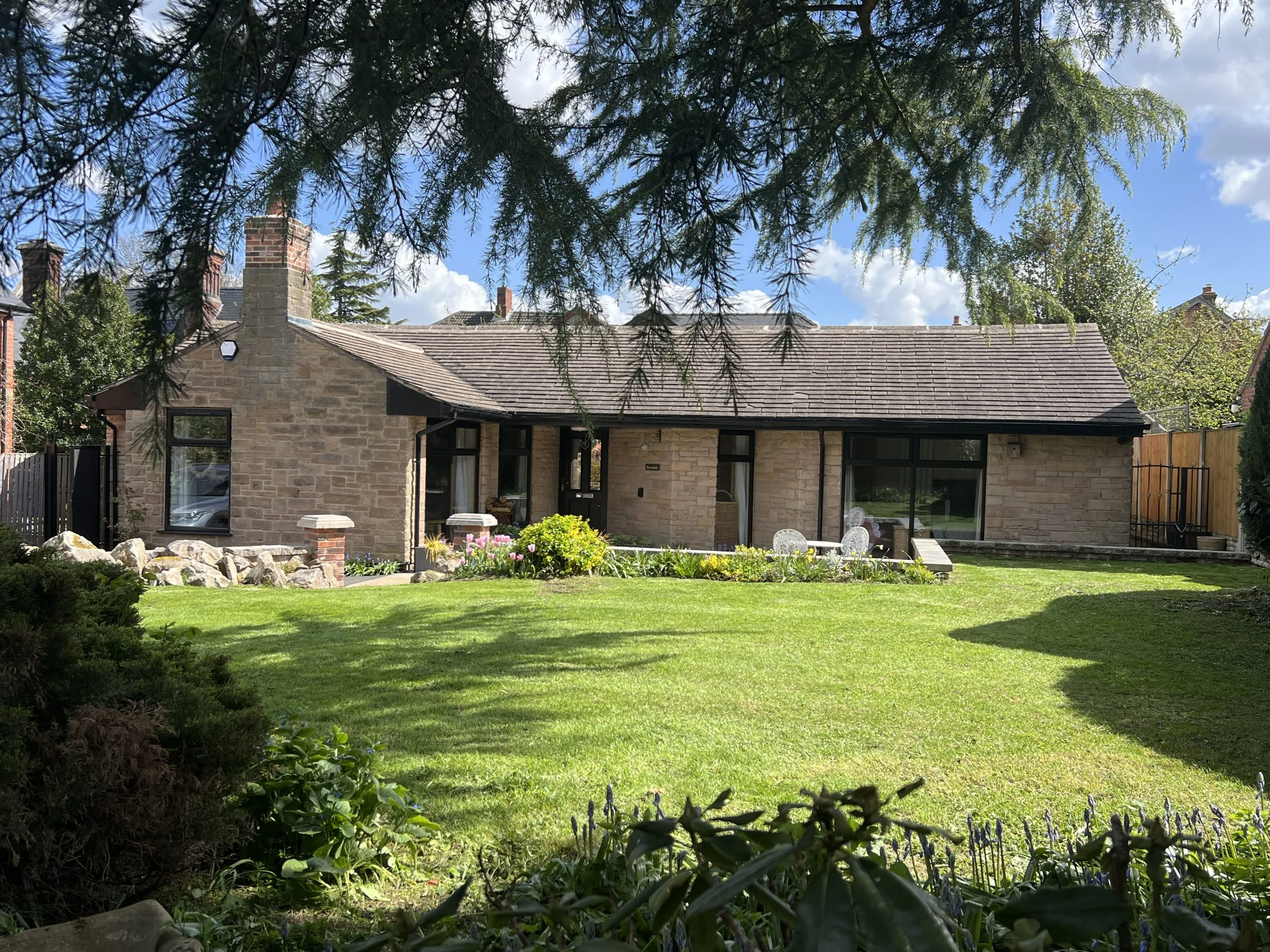 a house with a large garden and trees at Havendale Accessible Holiday Cottage