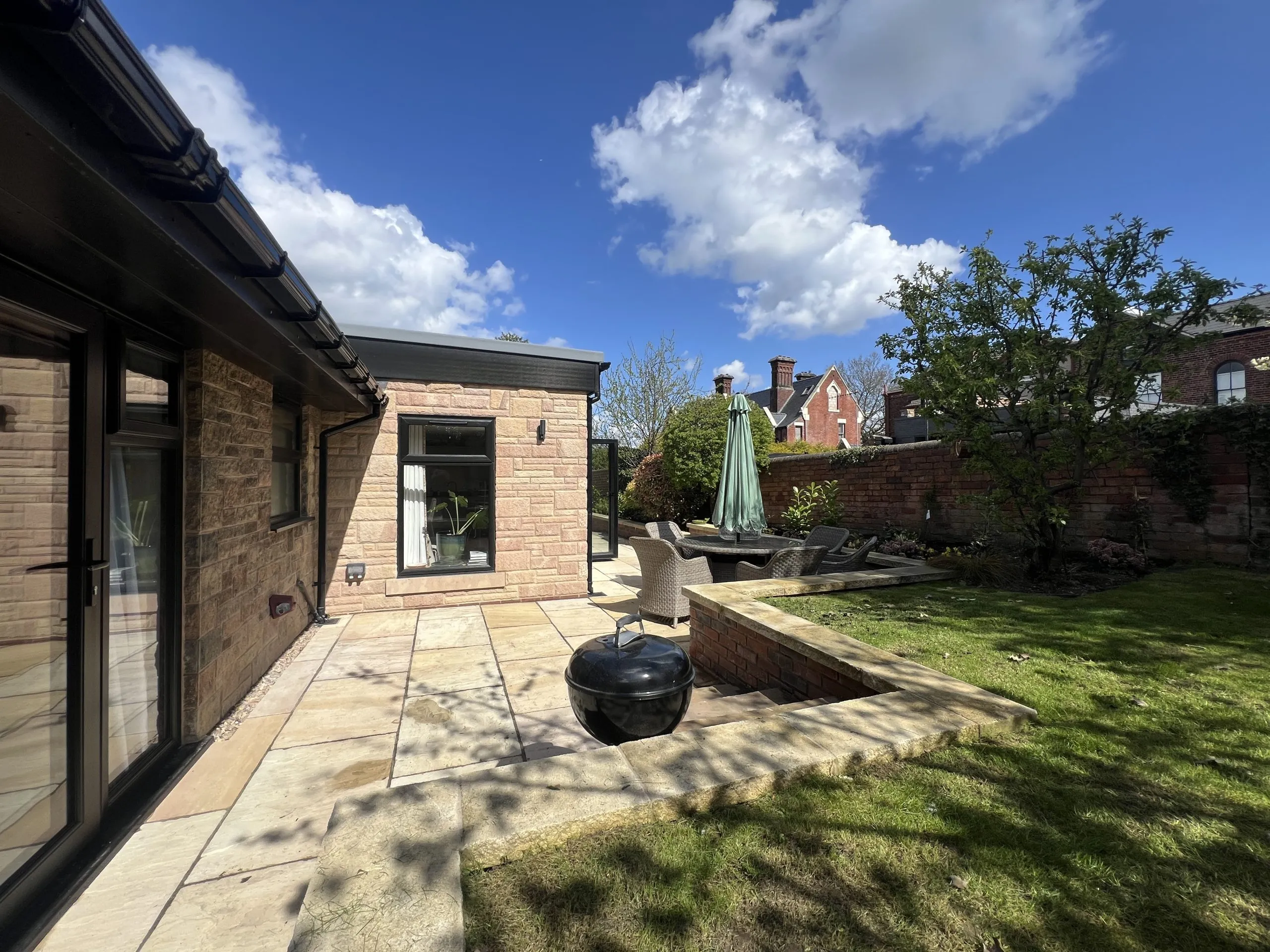 a patio with a barbecue and seating at Havendale Accessible Holiday Cottage
