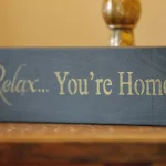 a wooden block with a sign that says relax you're home at Havendale Accessible Holiday Cottage